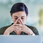 a woman looking at her laptop deep in thought